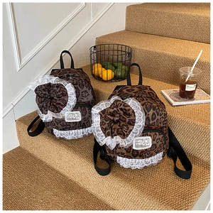 Detail of leopard print backpacks with large bows and delicate lace trim accents