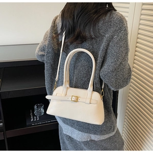 Close-up of cream white Boston bag featuring gold buckle details and textured leather