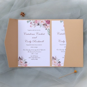 Détail d'invitation de mariage dorée découpée au laser avec décor floral à l'aquarelle