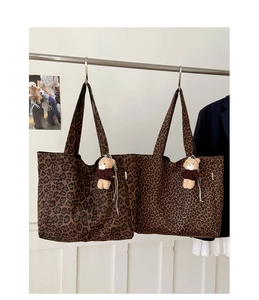 Close-up of leopard print canvas tote bag featuring a cute brown teddy bear keychain