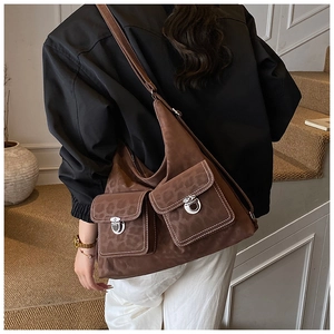 Detail of a brown suede hobo bag with leopard print, twin front pockets and silver locks