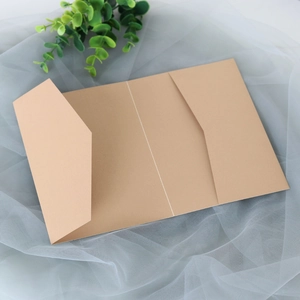 Vue à plat de la couverture d'invitation en kraft avec verdure sur fond de résille