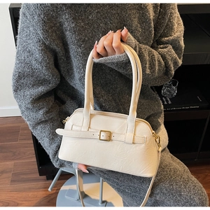 Detail of minimalist beige leather tote bag with metallic buckle and grain texture