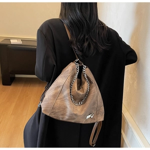 Retro brown hobo shoulder bag with metal chain detail worn on model back
