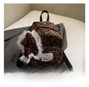 Close-up of leopard print backpack featuring white lace trim and a large matching bow charm