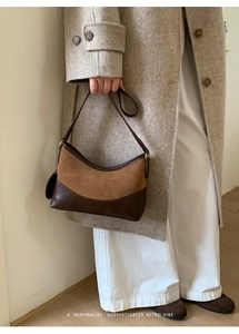 Detail of retro large bucket bag with brown leather and camel suede patchwork texture
