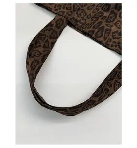 Close-up of wide canvas leopard print shoulder strap on a large capacity tote bag