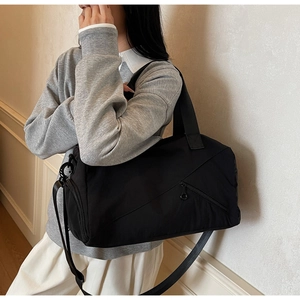 Gros plan d'un sac de fitness noir en nylon imperméable avec bandoulière sur un mannequin