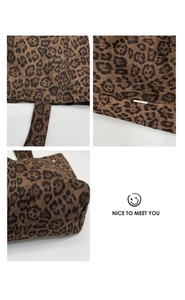 Detail view of leopard print canvas tote bag featuring double handles and side woven label