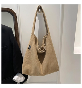Detailed shot of large khaki faux suede tote bag with Malivi logo on side hanging
