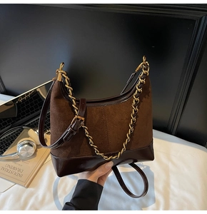 Detail view of coffee brown suede and patent leather hobo bag with gold chain strap