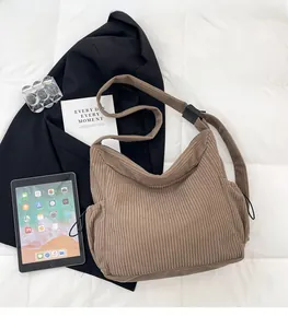 Detailed close-up of brown corduroy tote bag texture with functional side drawstring