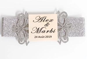 Detail of silver glitter laser cut wedding invitation belly band with floral patterns