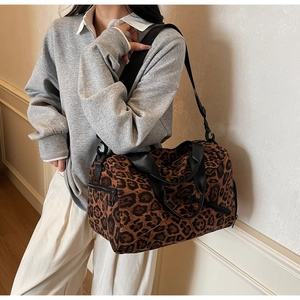 Vue détaillée du grand sac cabas léopard porté avec sa bandoulière noire réglable
