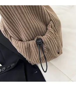 Detail of brown corduroy tote side pocket with adjustable drawstring and toggle