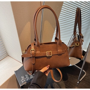 Detail view of brown vintage leather bag with retro gold buckles and adjustable strap