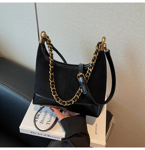 Detailed shot of black patchwork bag with vintage gold chain and adjustable leather strap