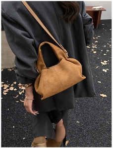 Brown suede crossbody bag with soft pleats and slim strap in a minimalist street style