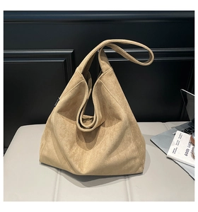 Close-up of camel suede tote bag with magnetic clasp and spacious interior detail