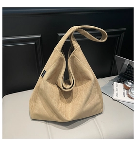 Detail of camel faux suede tote bag featuring internal magnetic clasp and woven brand tag