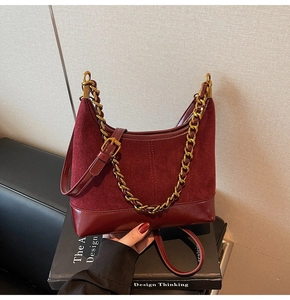Detailed macro view of burgundy suede and leather patchwork with golden chain accent