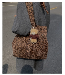Detailed shot of leopard print canvas tote bag with a cute plush bear charm on strap