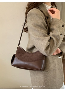 Detail der braunen Wildleder-Matte-Textur und Markenseitentasche der Schultertasche