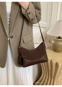 Detail of dark brown suede and leather patchwork shoulder bag with gold hardware buckle