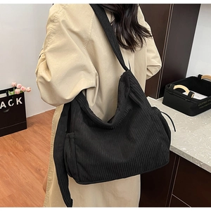 Detailed back view of a large black corduroy tote bag with textured stripe fabric