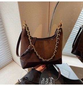 Detail of brown suede and leather hobo bag with gold chain strap and elegant texture