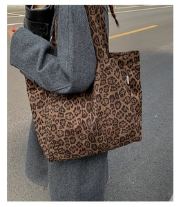 Close-up detail of leopard print canvas tote bag featuring neat stitching and side label