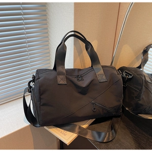 Détail du sac de voyage noir en nylon avec compartiment à chaussures et grande poche