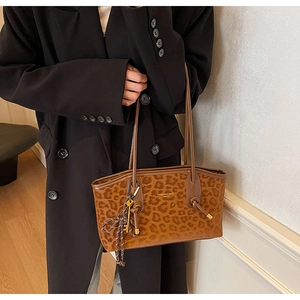 Gros plan d'un sac cabas léopard avec lettrage mode et pendentif clé dorée élégant
