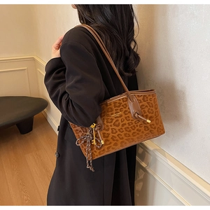 Détail du sac cabas léopard avec lettrage doré et pendentif clé en corde tressée élégant