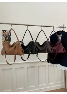 Detail view of stylish dumpling tote bags in four colors hanging on a metal rack