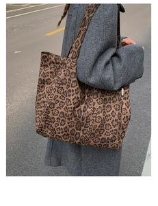 Close-up of leopard print canvas tote bag with side label showing fabric texture and detail