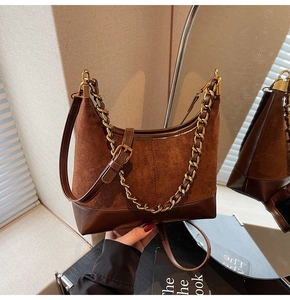 Detail of retro brown suede and leather splicing hobo bag with gold chain strap