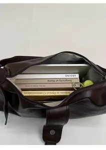 Detail view of large tote interior holding books and tablet with herringbone lining
