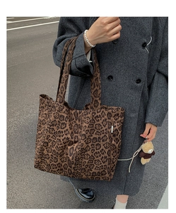 Detail of leopard print canvas tote bag featuring a cute plush bear charm accessory