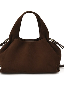 Vintage dark brown suede tote bag with golden rings and drawstring details on white background