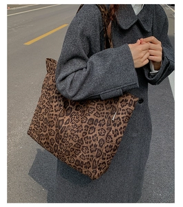 Detail of a leopard print canvas tote bag styled with a gray winter wool coat