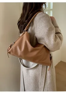 Detail of brown lychee texture leather hobo bag with silver metal ring and side strap