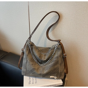 Detail of vintage grey distressed hobo bag featuring adjustable brown strap and silver chain