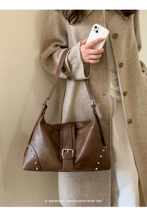 Detailed macro of vintage brown leather tote bag with silver buckle and metal rivets