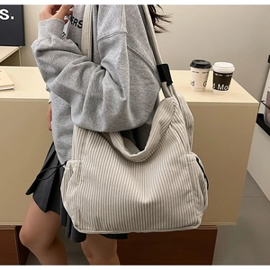 Detail of light beige corduroy tote bag showing soft ribbed texture and side drawstring
