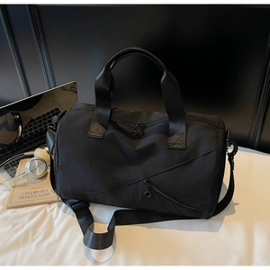 Gros plan d'un sac de sport noir en nylon avec fermetures éclair et bandoulière réglable