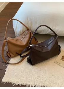 Close-up of caramel and dark chocolate tote bags with lychee grain texture and zipper detail