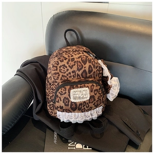 Detail of leopard print mini backpack with white lace trim and decorative square patch