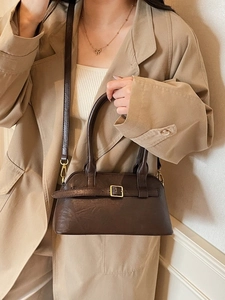 Minimalist dark brown leather Boston bag with gold buckle detail and adjustable shoulder strap