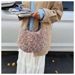 Dettaglio della texture in finta pelliccia riccia su questa borsa a secchiello rosa